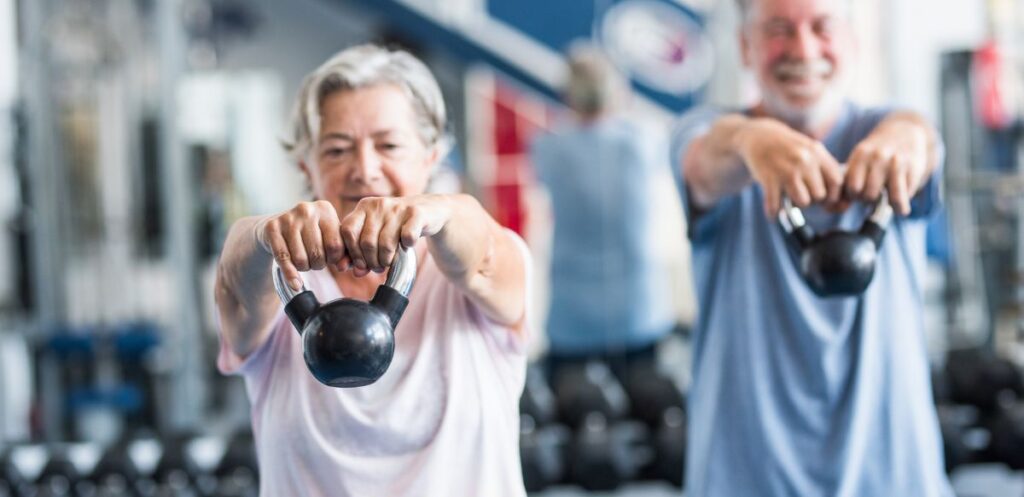 older woman using kettlebells